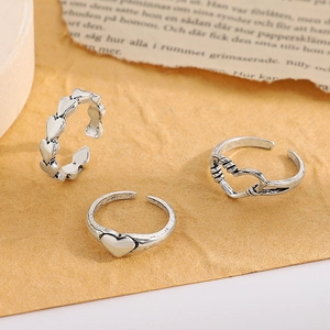 Detailed view of vintage silver hollow heart rings on a rustic textured background