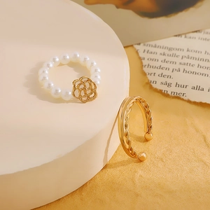 Detail of beaded pearl ring with gold flower and twisted rope open ring jewelry set