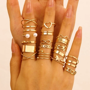 Detailed view of layered gold fashion ring set featuring pearls and heart designs