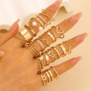Detail of 22-piece gold knuckle ring set with heart and butterfly designs on hand