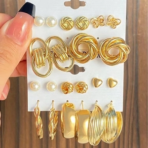 Set di orecchini in lega dorata con perle e cerchi su cartoncino bianco