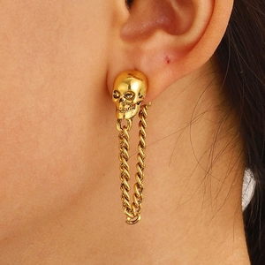 Detailaufnahme eines Vintage-Gold-Totenkopf-Ohrsteckers mit punkiger, langer Gliederkette