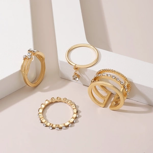 Close-up of four-piece gold stacked rings set with sparkling crystals on geometric stands