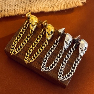 Punk-Stil Totenkopf-Kettenohrringe in Gold und Silber auf rustikalem Holzdisplay