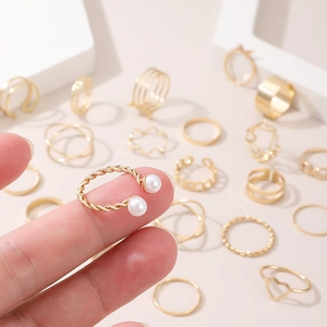 Gold-tone 22-piece multi-joint ring set with pearls, hearts, and twisted designs