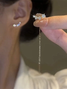 Details von silbernen Stern-Ohrringen mit glitzernden Kristallen in der Hand