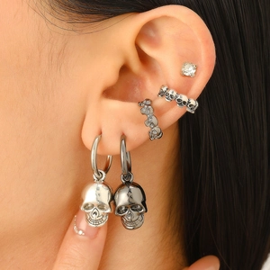 Makroaufnahme von Gothic-Totenkopf-Ohrringen und Ear-Cuffs in antiker Silberoptik