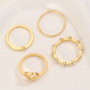 Set of four gold-plated alloy rings featuring hollow heart and sparkling zircon accents