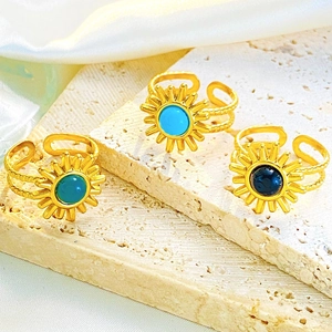 Macro-detail van zonnestraal ringen met turquoise en groene stenen op een steen