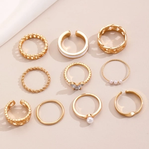 Detailed view of 10-piece gold ring set featuring pearls, butterflies, and textured bands