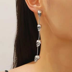Gotische Totenkopf-Ohrhänger in Vintage-Silber am Modell mit langen Quasten-Elementen