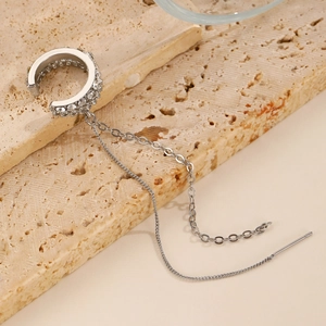 Detail von silberner Ohrmanschette mit Strasssteinen und zwei Lagen Quastenkette