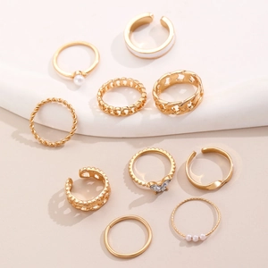 Detail of 10-piece gold ring set featuring pearl, butterfly zircon and chain designs