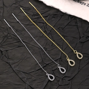 Detailansicht goldener und silberner Quastenkette-Ohrringe mit Zirkon-Anhängern