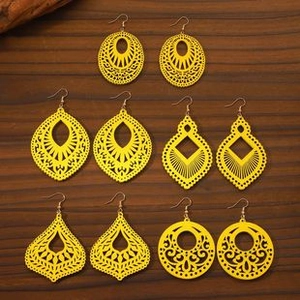 Detailed overhead view of five pairs of vibrant yellow hollowed-out wooden earrings