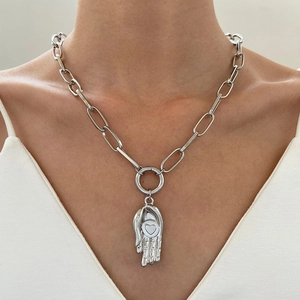 Silberne Metallkette mit groben Gliedern und Herz-Hand-Anhänger an einem Model