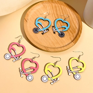 Detail of colorful heart stethoscope wooden earrings in sky blue, pink, and yellow