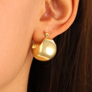 Close-up of a model wearing high-polished gold hollow hoop earrings for women