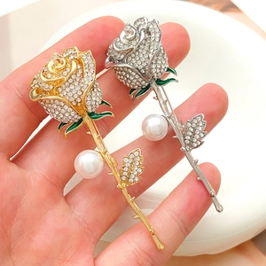 Elegant rose brooches set in gold and silver with white rhinestones and pearl details