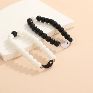 Vista detallada de las pulseras de cuentas Yin Yang a juego en soportes geométricos