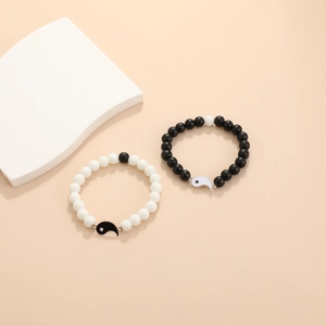 Detalle de pulseras de cuentas Yin Yang para parejas con cuentas mates y colgantes