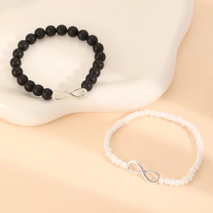 Pulseras de cuentas con símbolo de infinito para parejas en una bandeja de cerámica blanca