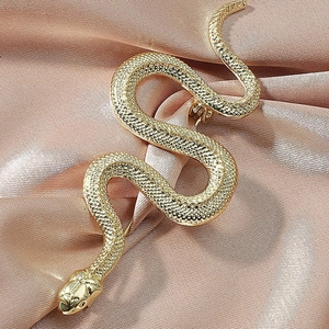 Detailed macro view of a gold-plated snake brooch with intricate scale textures