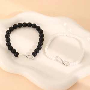 Detalle de pulseras de infinito con cuentas negras mate y cuentas blancas brillantes