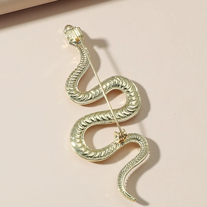 Detail view of the golden snake brooch back with scale texture and needle closure