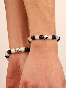Detalle de pulseras de cuentas Tai Chi Yin Yang para parejas en piedra blanca y negra