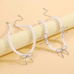 Dettaglio collana di perle con ciondolo a fiocco argento e chiusura a moschettone regolabile