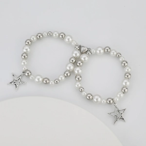 Detalle de hebilla magnética de corazón y dije de estrella en pulseras de cuentas
