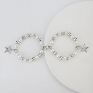 Detalle de pulseras de cuentas con colgantes de estrella y cierre magnético de corazón