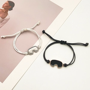 Detalle de pulseras trenzadas ajustables con dijes de ojos sobre una revista de moda
