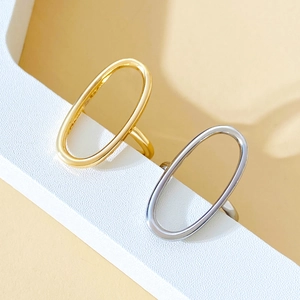 Detail of gold and silver hollow oval rings on a white geometric stand with warm lighting