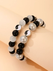 Vista detallada del juego de pulseras de cuentas blancas y negras con colgante circular Yin Yang