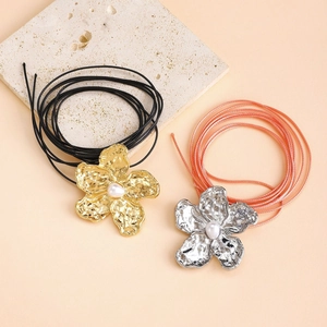 Detailed macro view of alloy flower necklaces with metallic texture and pearls