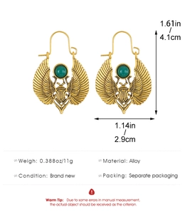 Detailed view of Egyptian scarab beetle earrings with size specs and green stone