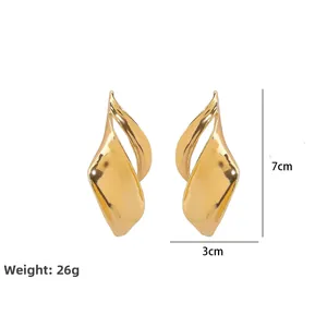 Detail view of large gold twisted leaf earrings showing 7cm length and 26g weight