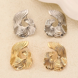 Detailed view of spiral geometric earrings in polished gold and silver metal finishes