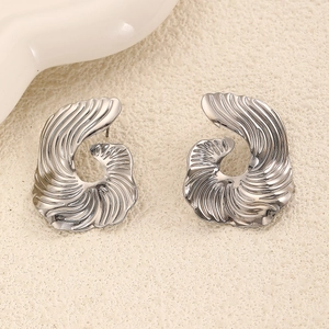 Macro view of silver geometric irregular earrings with radiant pleated metal texture