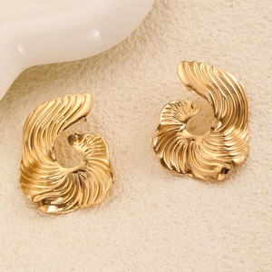Detailed macro view of golden geometric stud earrings featuring radial metal textures