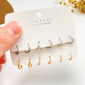 Set di orecchini a cerchio minimalisti in oro e argento su carta per gioielli