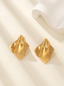 Detailed view of gold irregular geometric earrings with textured metallic finish and shine