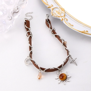 Detail of leather and silver chain necklace with moon and star celestial pendants