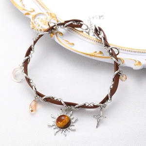Detail of double-layer brown leather and silver chain necklace with sun and moon pendants