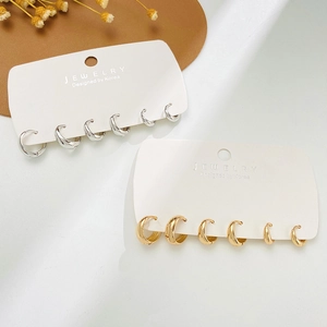 Set di orecchini a cerchio minimalisti in oro e argento in tre misure su espositore