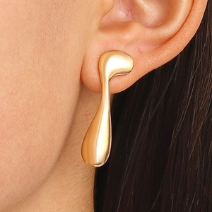 Close-up of elegant gold fluid water drop earrings with a polished metallic finish