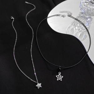 Dettaglio dei pendenti a stella con texture a spirale su catena d'argento e cordino nero