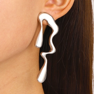 Close-up of elegant liquid metal drop earrings with irregular twisted silver texture